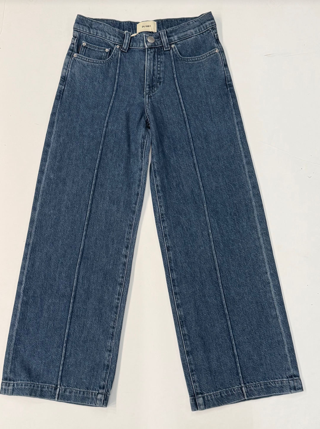Pair of Dl1961 blue jeans on a white background